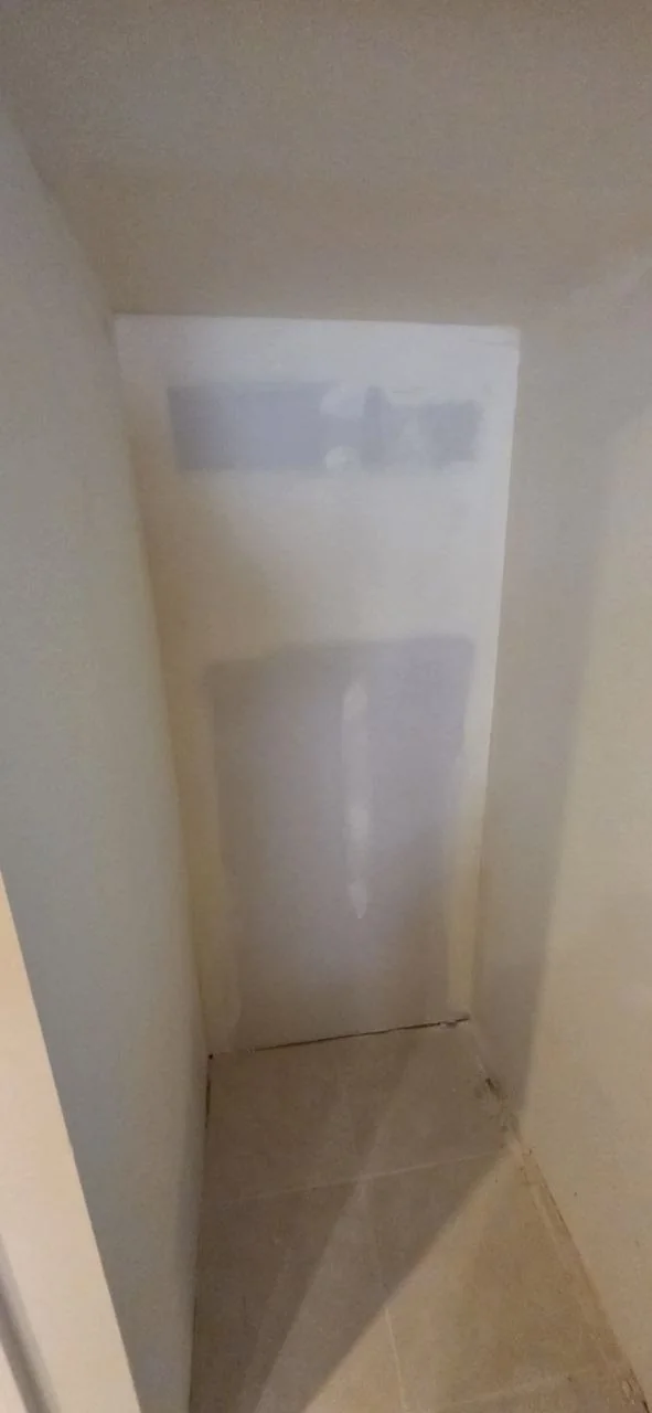 Closet interior with flat drywall sheets visible before finishing.